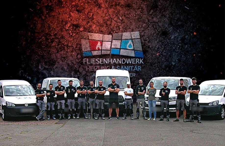 Das Team von Andreas Hilger vor den Firmenfahrzeugen